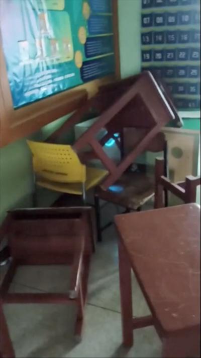 Tables piled in the corner of a classroom 