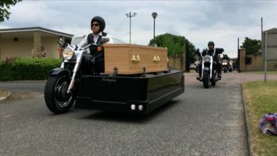 Motorbike carrying a coffin in a funeral procession