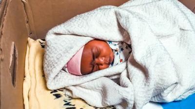 A newborn baby in a care box