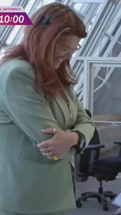 A woman smiles in the control room as she speaks to the astronauts