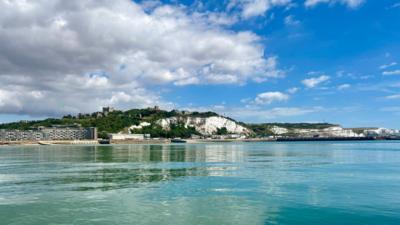 Calm seas and blue skies with the white cliffs of Dover in the background