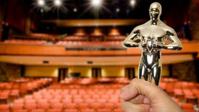 A graphic of person holding an award