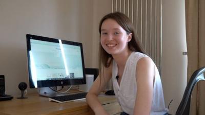 Cara sitting at her desk