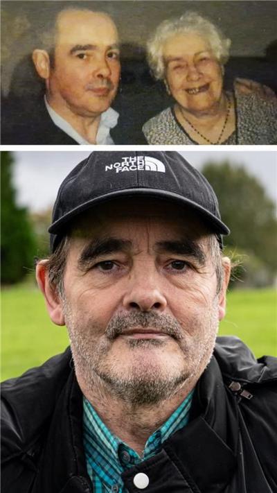 A man sitting in a cemetery with a short greying beard is wearing a black baseball cap and a black jacket over a green checked shirt