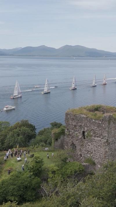 Iachtaichean a' seòladh seachad air Caisteal Dhùn Ollaigh le Muile air an cùlaibh