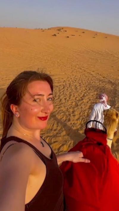 A woman riding a camel in a desert