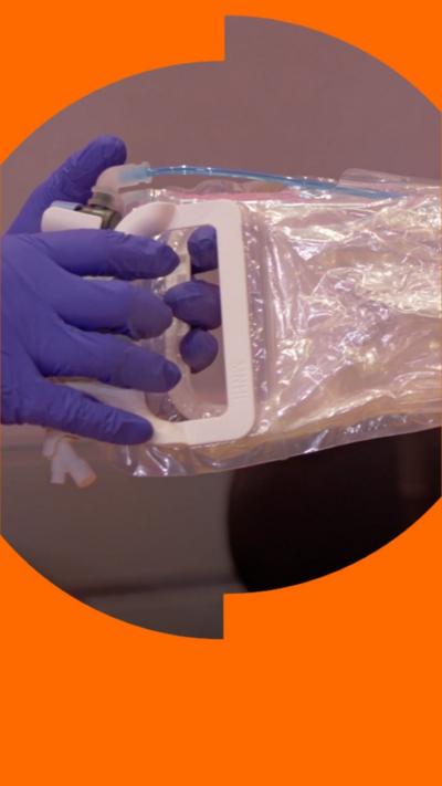 Purple gloved hands holding the new device which has plastic handles.