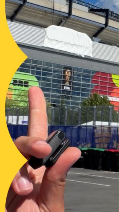 Hand pointing at a covered up sign on the side of a stadium