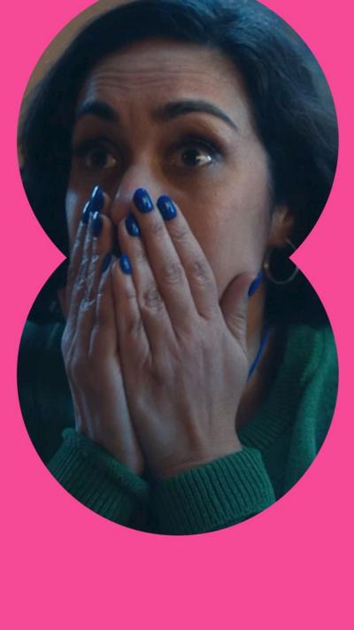 A woman looks surprised and holds her hands over her mouth