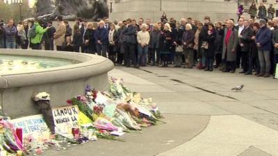 Large crowd of people stands silent in Trafalgar Square, London