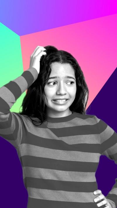 A woman scratches her head, looking confused