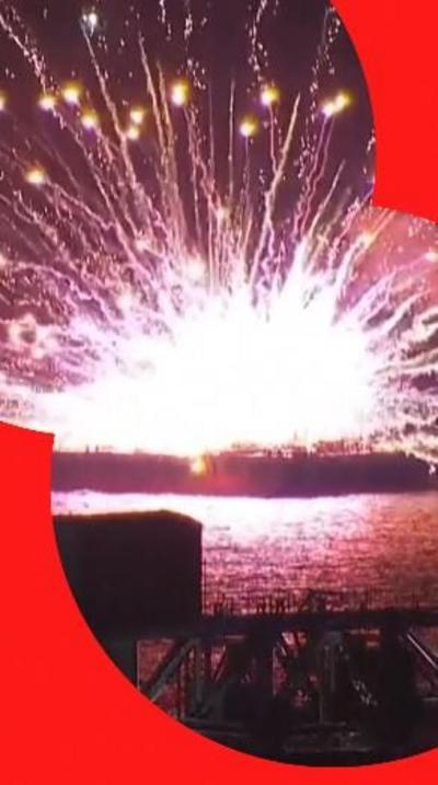 Flames from explosion on boat as fireworks erupt