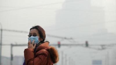 Woman standing in smog in Beijing