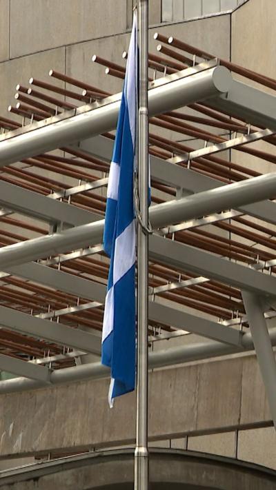 Scottish Saltire flying at half mast outside the Scottish Parliament.