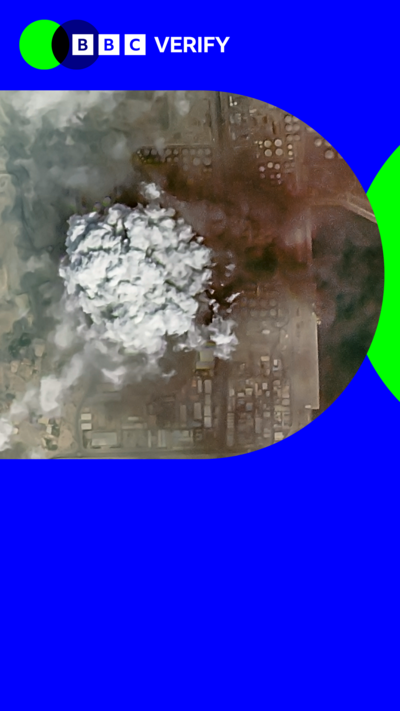 A composite image showing two satellite images taken in Iran. The left image shows a cargo ship moored at a dock off the coast of Iran that has been hit by a strike. A tall, thin cloud of black smoke is billowing high above the ship. The image on the right shows the aftermath of a strike on a city in Iran. A large grey mushroom cloud of smoke covers several buildings. The BBC Verify branding is overlaid on top.