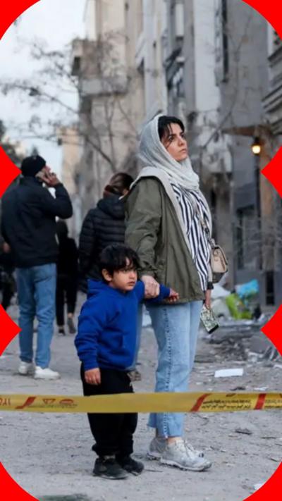A woman and her child look at the aftermath of a US-Israeli air strike on a police station in Tehran in early March