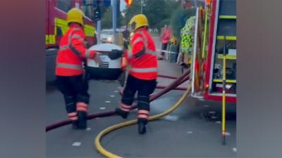 Firefighters lift delivery robot over hoses