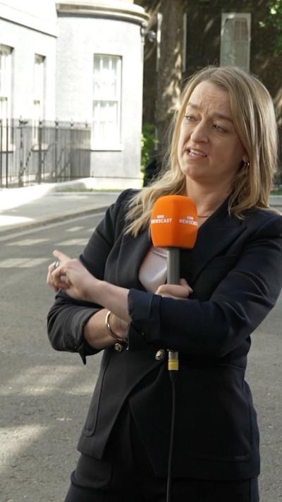 Laura Kuenssberg standing in Downing Street holding a microphone.