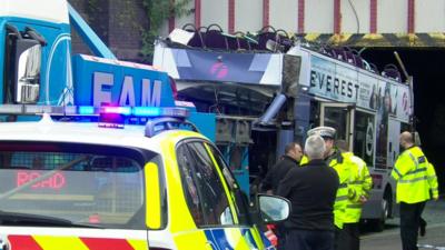 Emergency services surround double-decker bus which had its roof ripped off