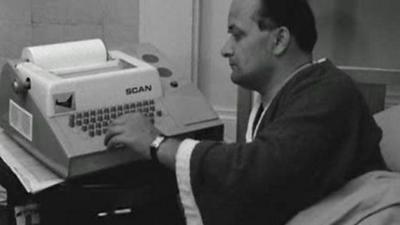 Industrial consultant Rex Malik using home computer terminal