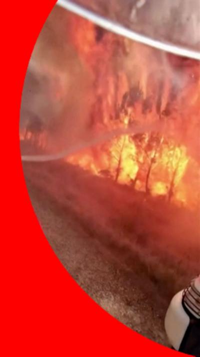 A red hose pipe attempts to extinguish large flames.