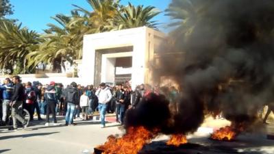 Young Tunisian graduates block the road with burning tyres in Sidi Bouzid in solidarity with protest in the central Tunisian town of Kasserine