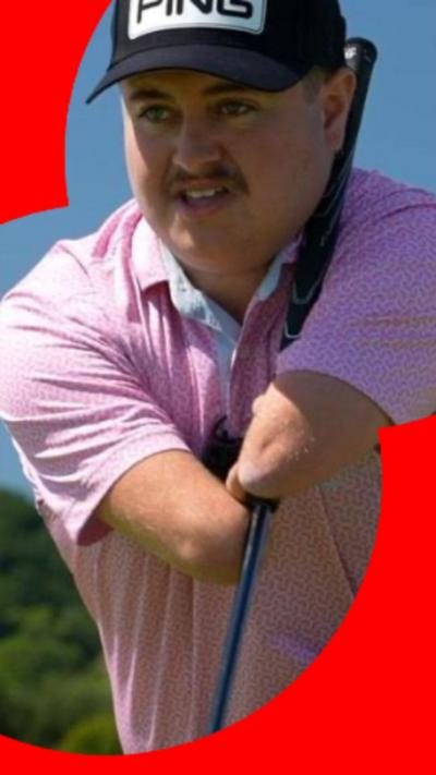 A young golfer with no hands kneels to assess the golf course, wearing a pink polo shirt and black baseball cap.