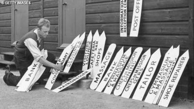 A man prepares signs for the Olympic Town at Richmond Park.