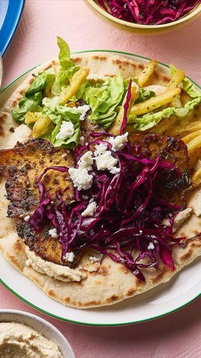 Top down image of tofu, red cabbage, green veg and feta on a wrap