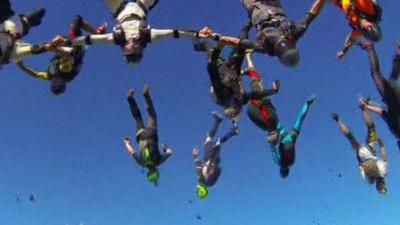 164 skydivers forming the shape of a flower