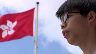 Hong Kong activist Joshua Wong with Hong Kong flag in the background
