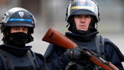 An armed policeman and a CRS riot policeman in Saint-Denis