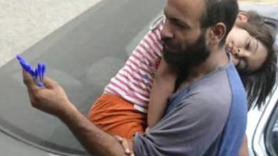 Halim with three-year-old child selling pens in Beirut