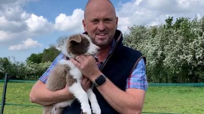 Man with sheep dog puppy