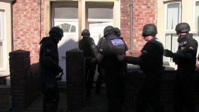 Police officers raiding a property used for modern slavery