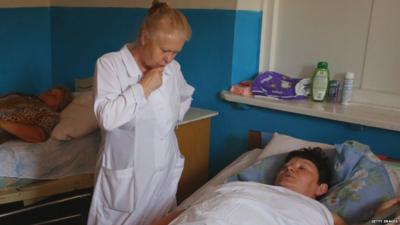 A nurse attends a woman after she was injured by shelling between Ukrainian forces and pro-Russian separatists.