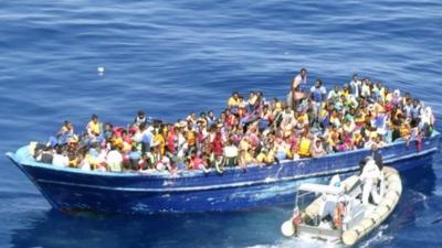 A boat crowded with refugees off the Italian coast in the Strait of Sicily, 22 August