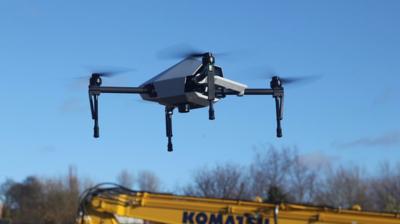 Drone hovers over a digger