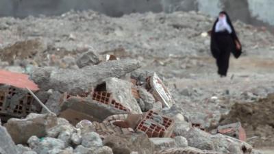 Woman amid rubble in Cizre
