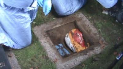 Bag of stolen goods and cash in a hole in a cemetery