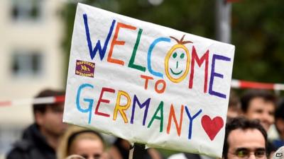 People welcome refugees with a banner reading "welcome to Germany" in Dortmund, Germany, Sunday, Sept. 6, 2015