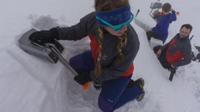 Young woman shovelling snow