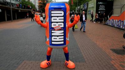 Performer wearing a giant Irn-Bru can mascot outfit