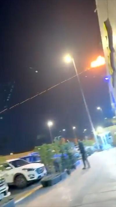 An interception explosion in the night sky. Cars and below below