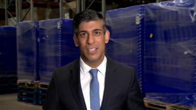 Rishi Sunak wearing a dark suit and a blue tie