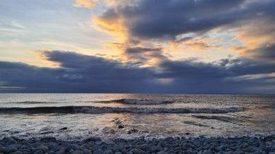 A view out on to the sea. The clouds are reflected in the waves.