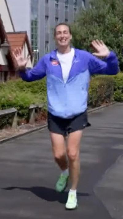 Jill Scott wearing blue jacket with black shorts and green shoes