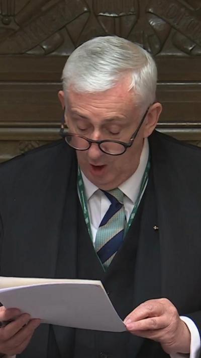 Speaker Hoyle in Parliament reading out of a piece of paper