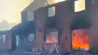 Fire raging inside of destroyed house