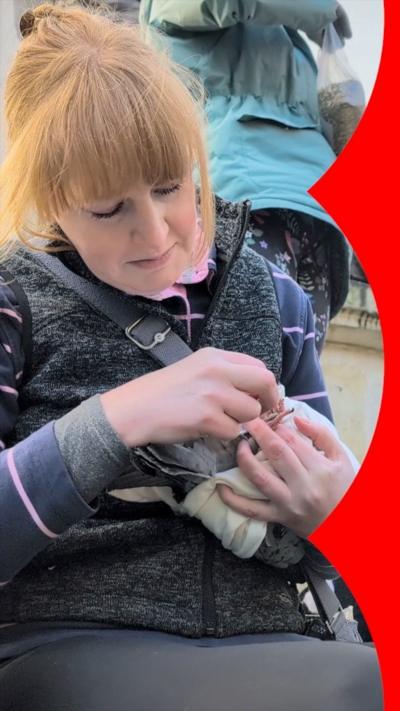 Woman with red hair holding a pigeon.